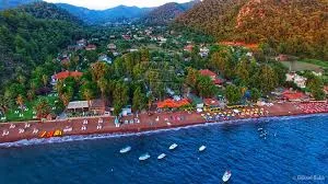 Ein luxuriöser Mercedes Vito für den VIP-Transport vom Flughafen Dalaman in die Region Fethiye Hisarönü, mit dem Berg Babadağ und dem Markt von Hisarönü im Hintergrund.