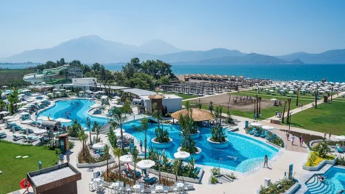 Dalaman Havalimanı'ndan Fethiye Liberty Fabay oteline ulaşım sağlayan Ege Vip Tur lüks transfer aracı ve modern otel giriş manzarası.