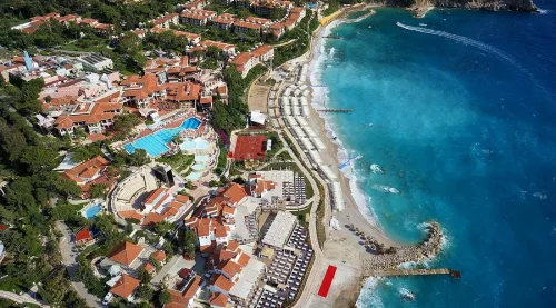 Dalaman Havalimanı'ndan Liberty Lykia oteline VIP transfer sağlayan lüks siyah Mercedes Vito araç, arka planda Babadağ manzarası ve Ölüdeniz-Faralya yolu.